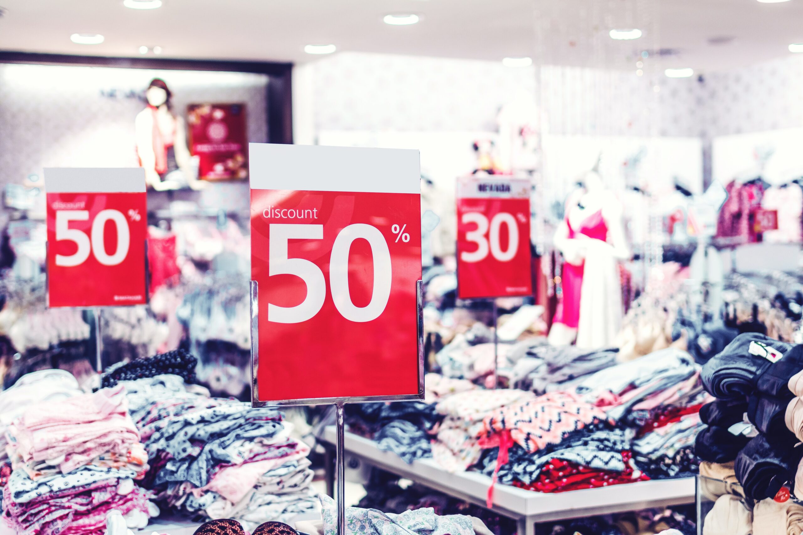 Discount signs on tables of merchandise.