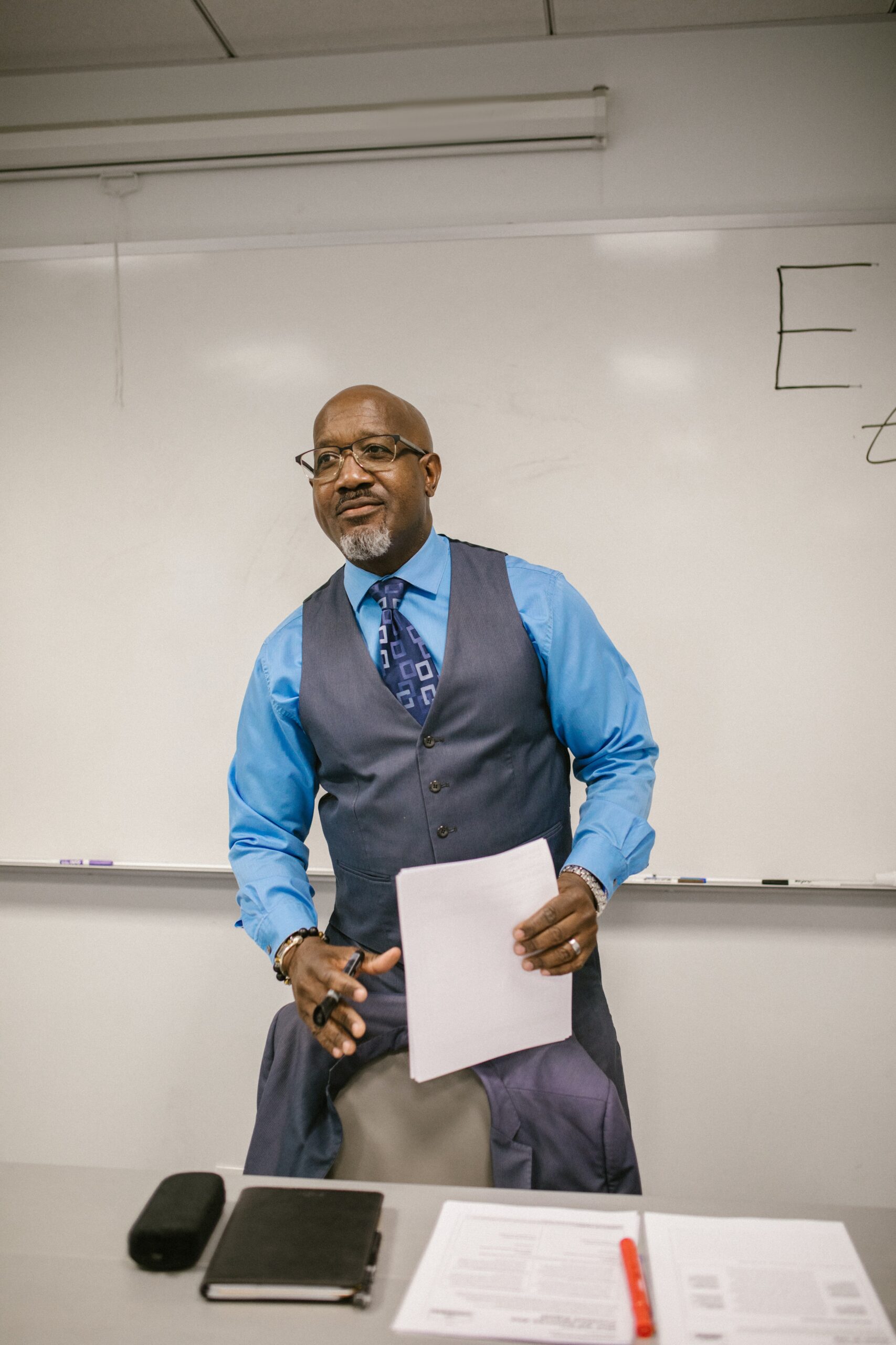 Teacher in suit holding his notes.