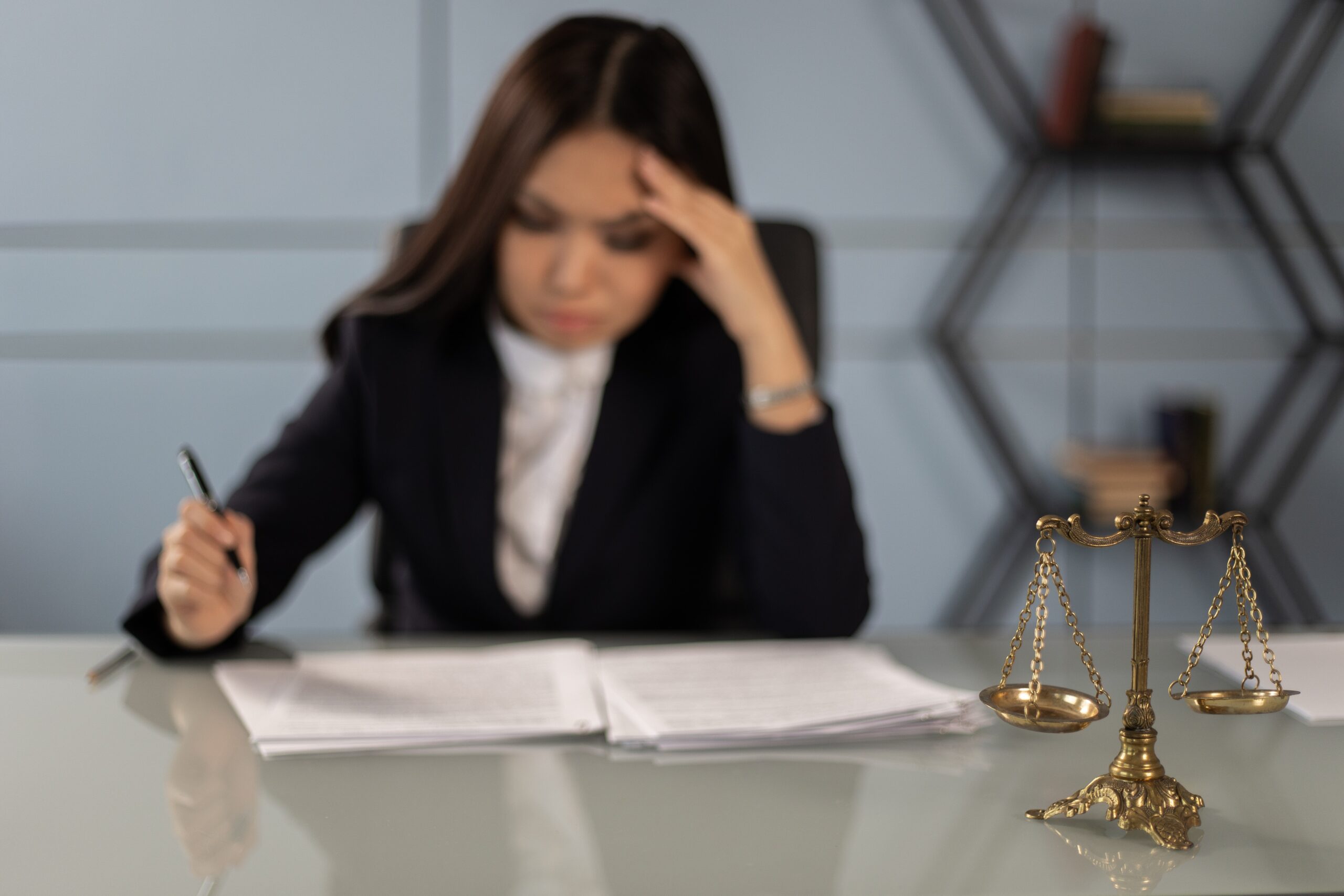 Woman sitting at desk and studying a document.