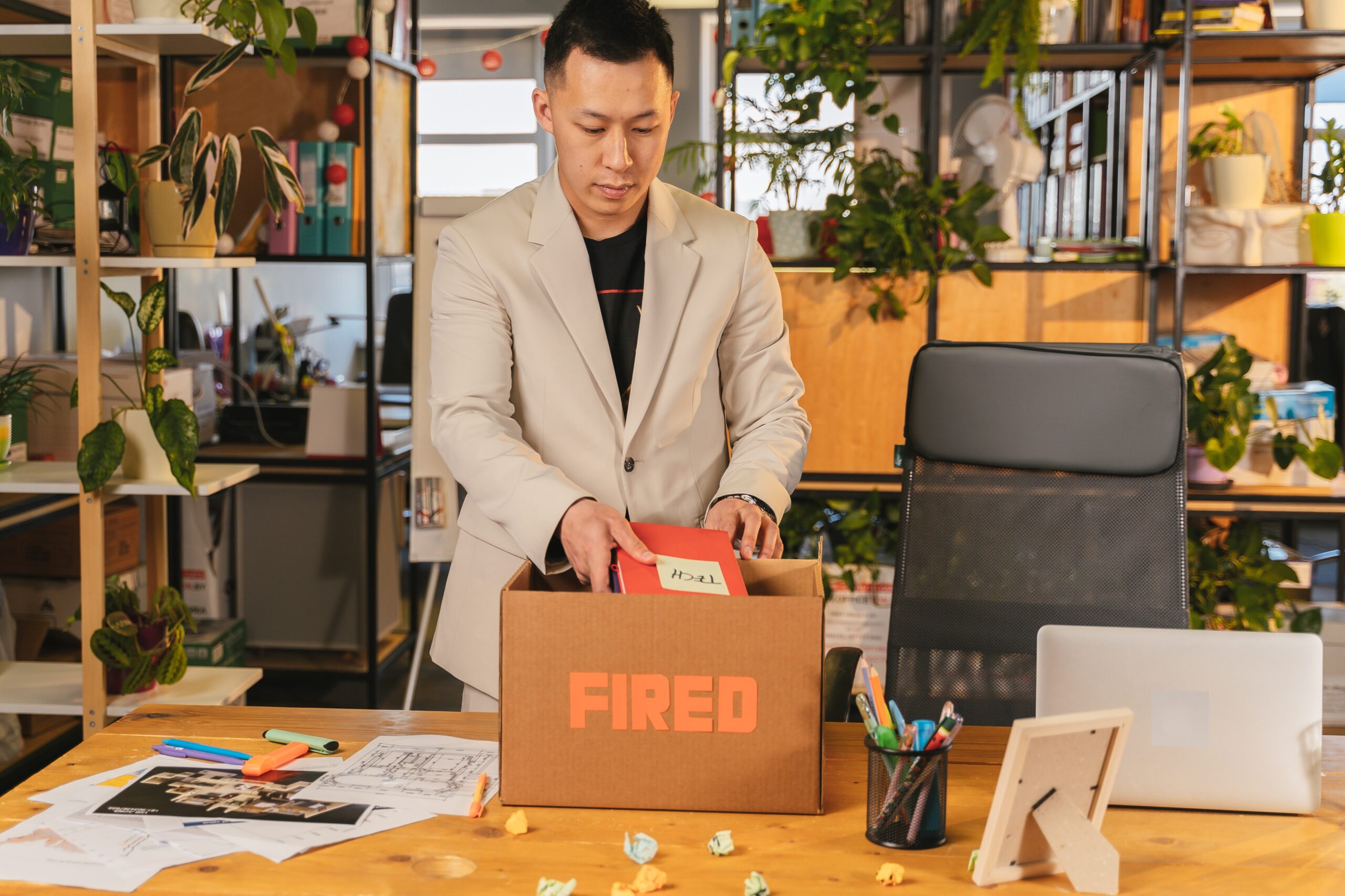 Man loading is things into a box marked "Fired."