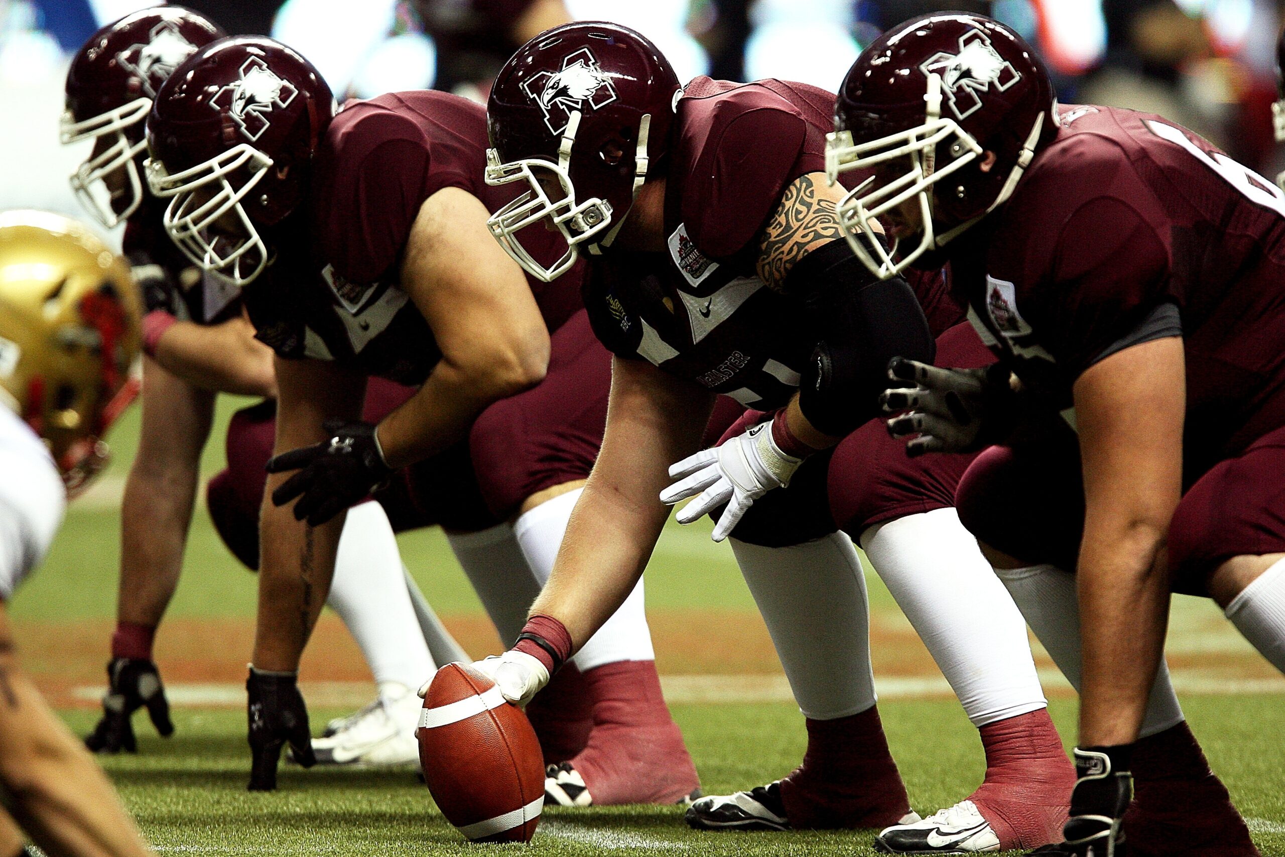 Football players at scrimmage line.