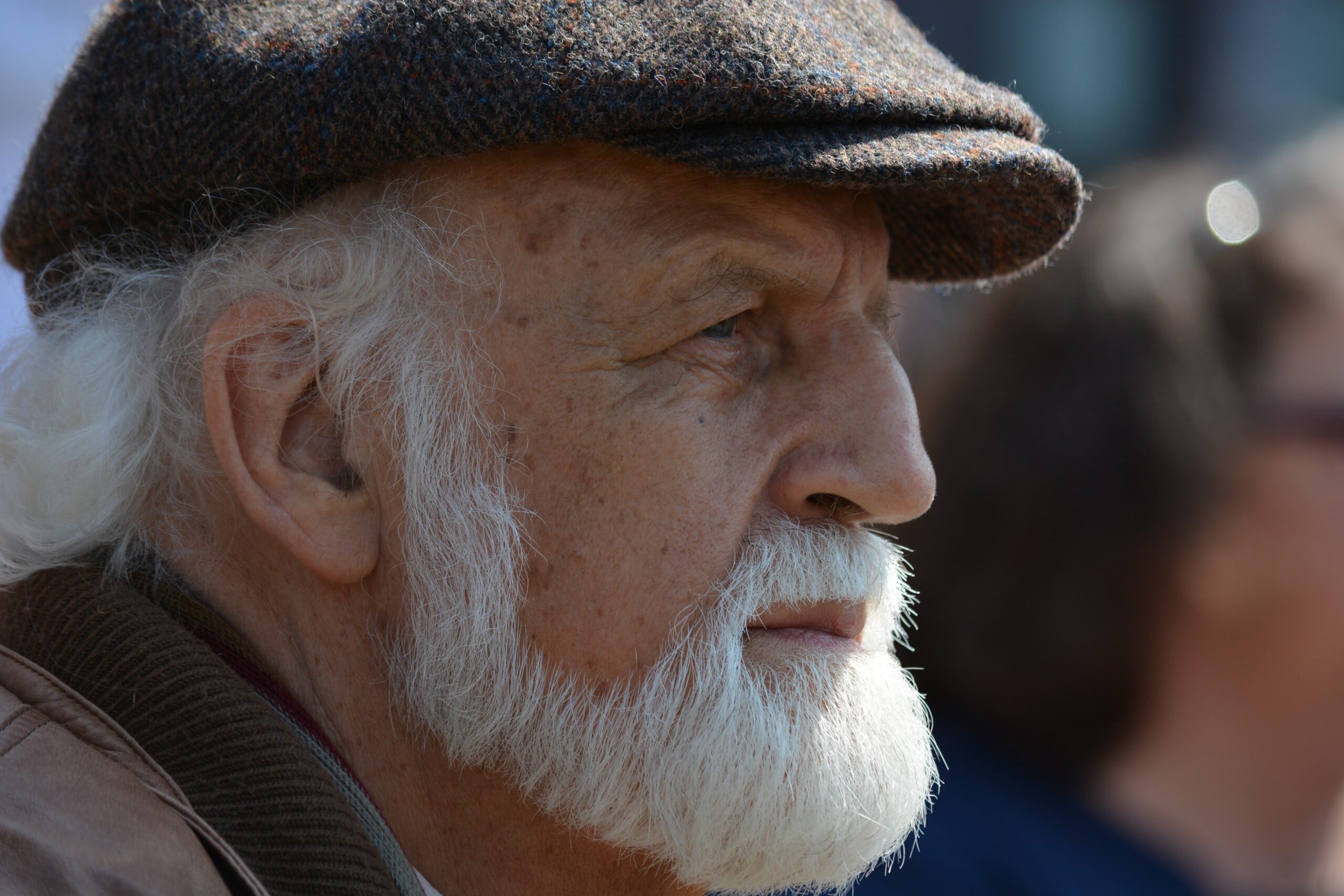 Older man with a white beard and a cap.