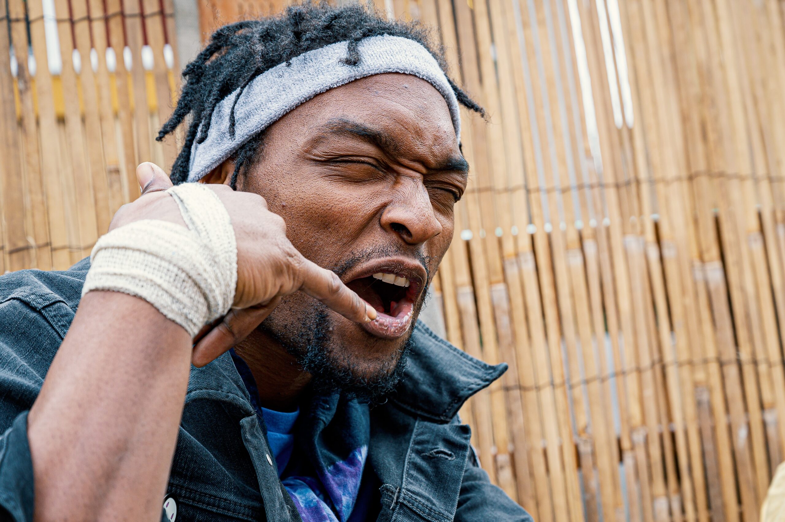 Man wearing a headband and using the "call me" sign.