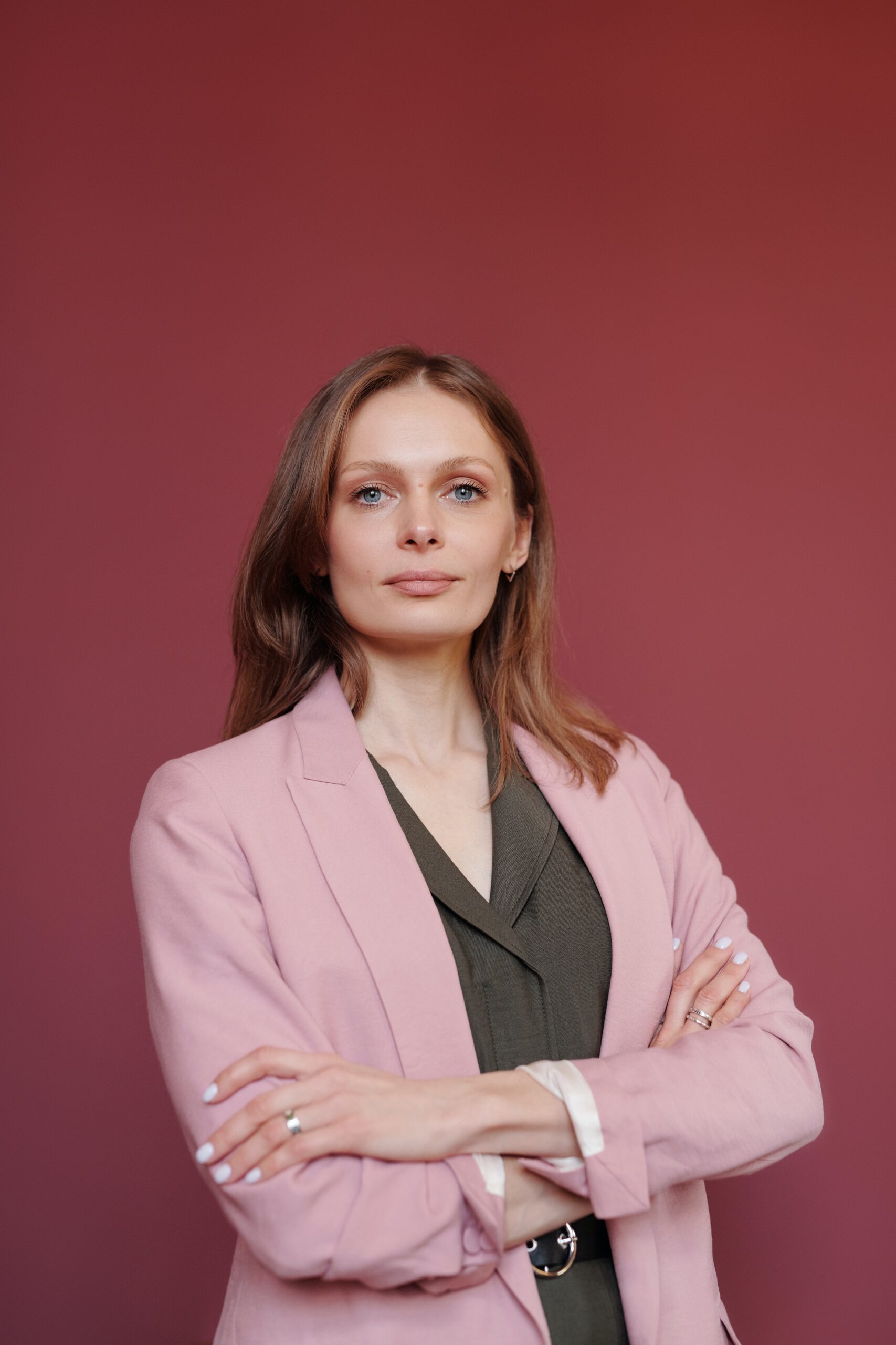 Woman wearing a pink jacket and looking confident and professional.