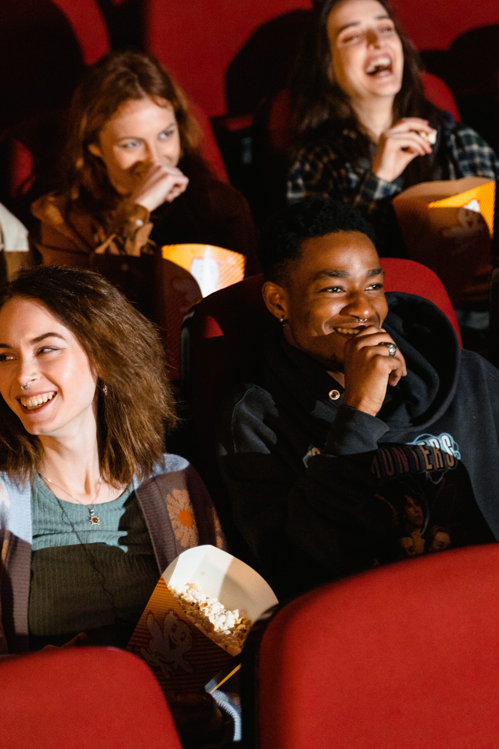 Young people sitting in an audience and laughing.