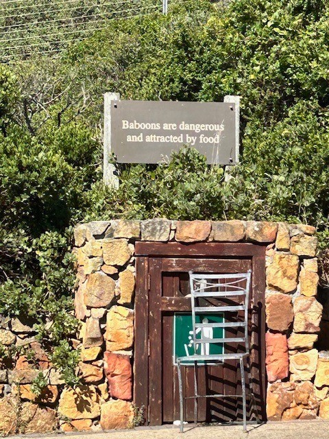 Sign in a park in South Africa that says "Baboons are dangerous and are attracted by food."