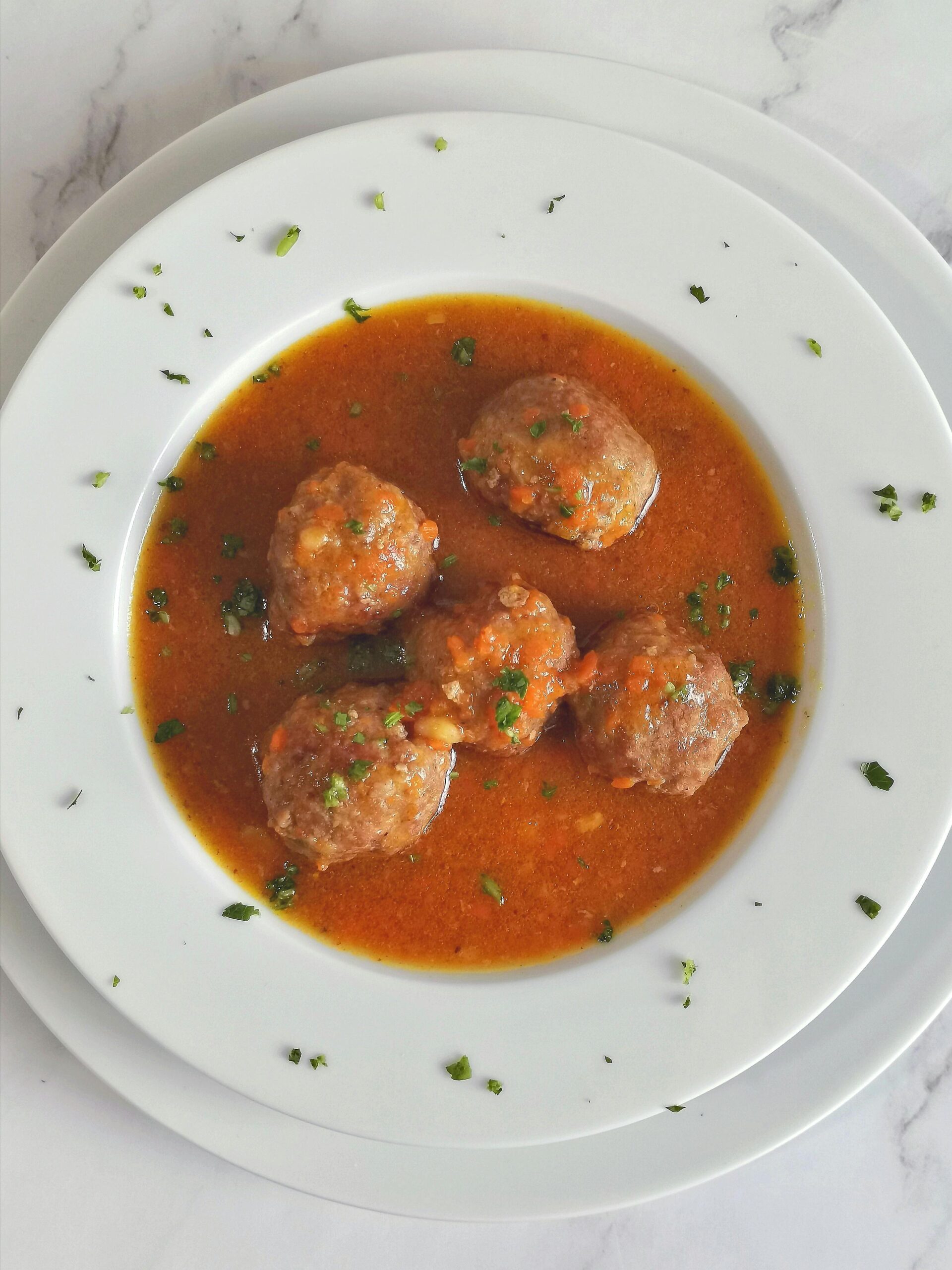 A bowl of meatballs in sauce.