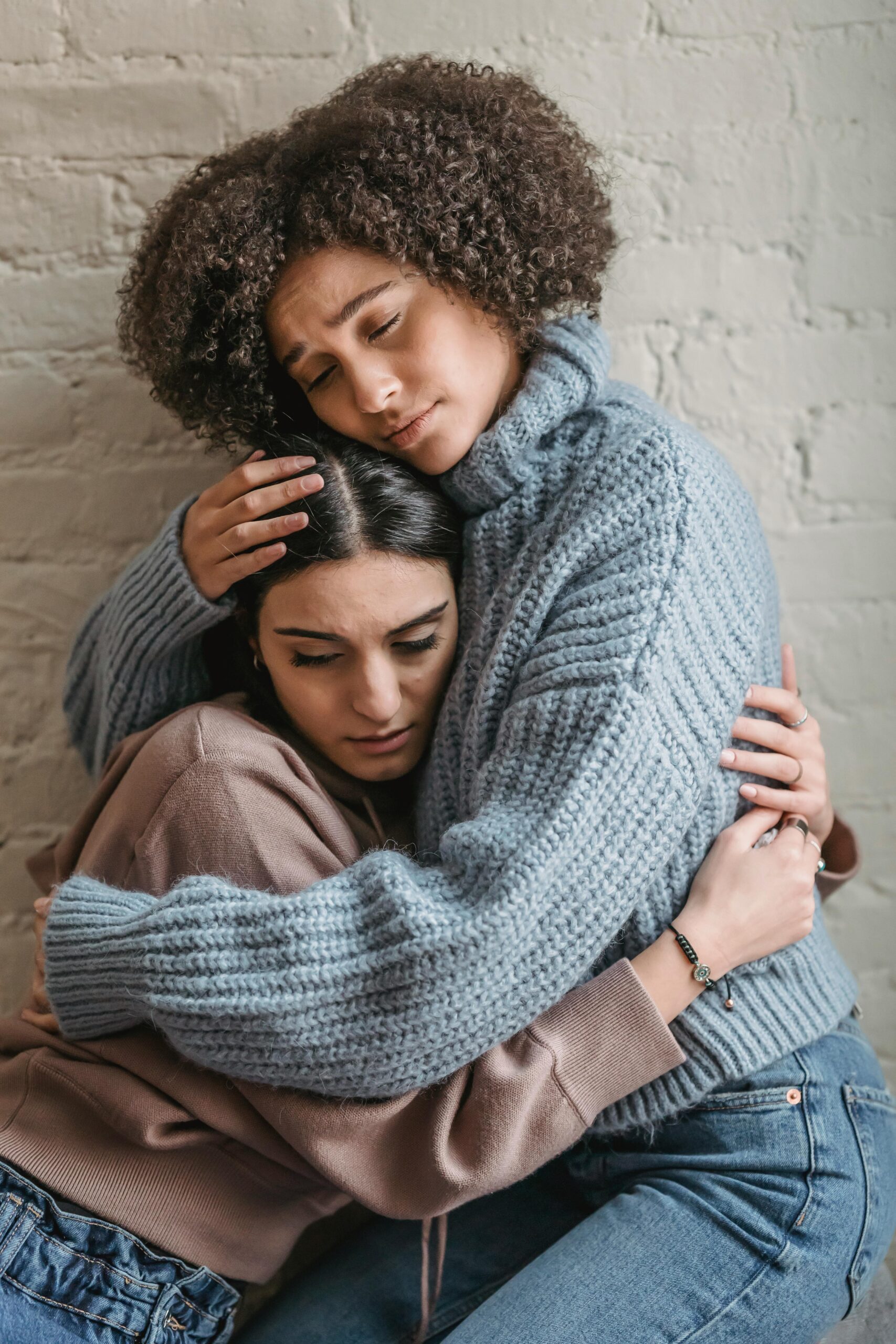 One woman comforting another woman.